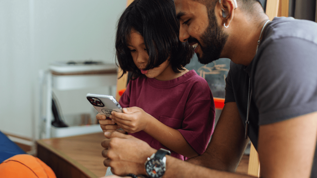 A person and a child looking at a cell phone.