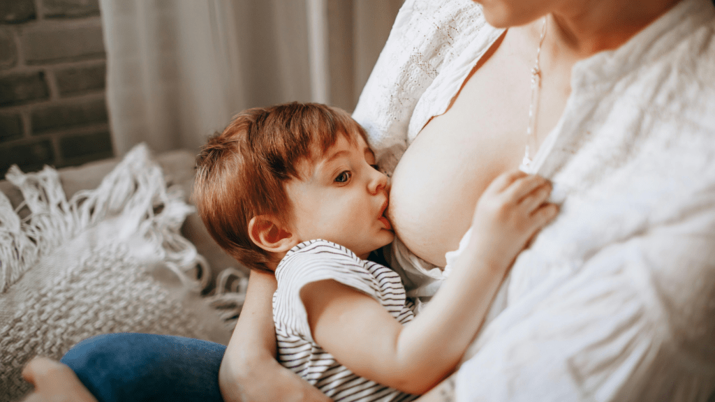 A person breastfeeding a baby while sitting on a couch.