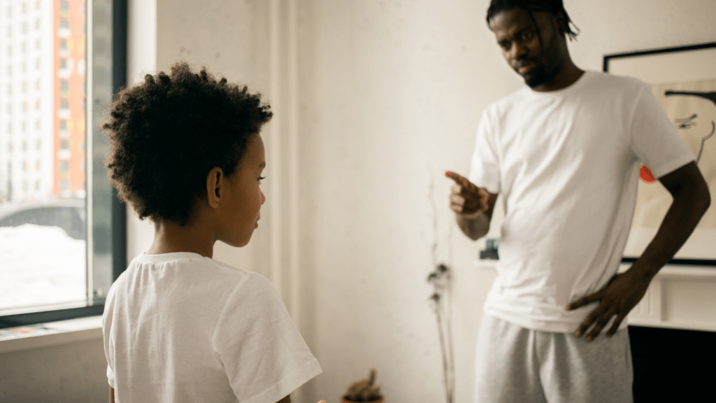 A person talking to a child in a living room.
