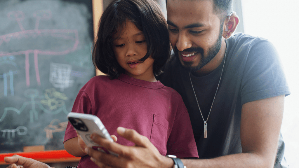 A person and a child looking at a cell phone.