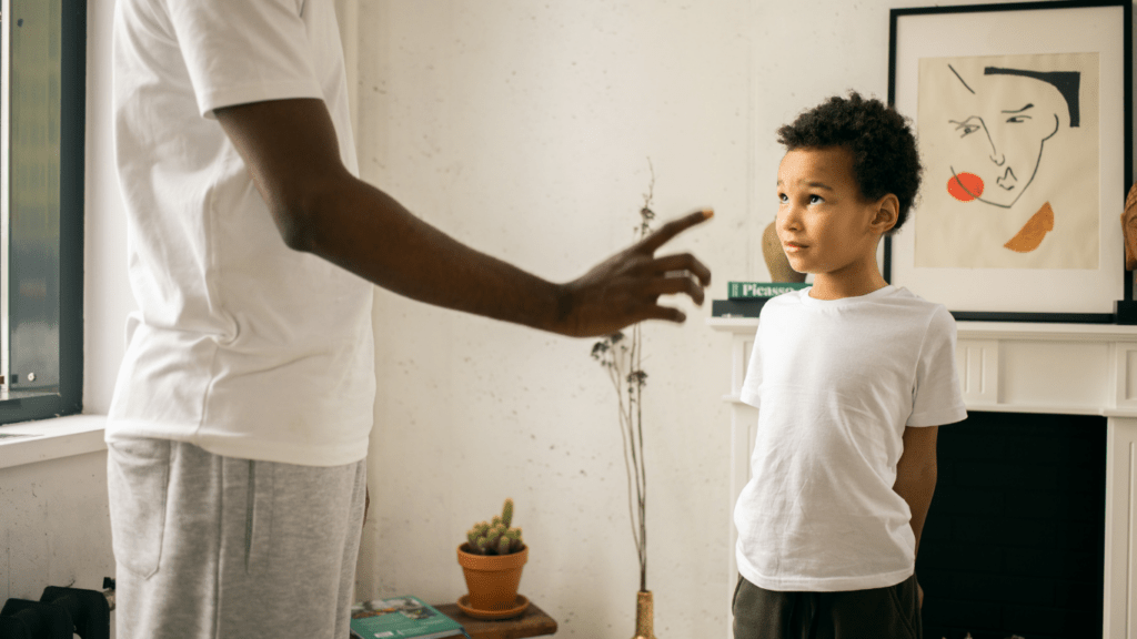 A person talking to a child in a living room.