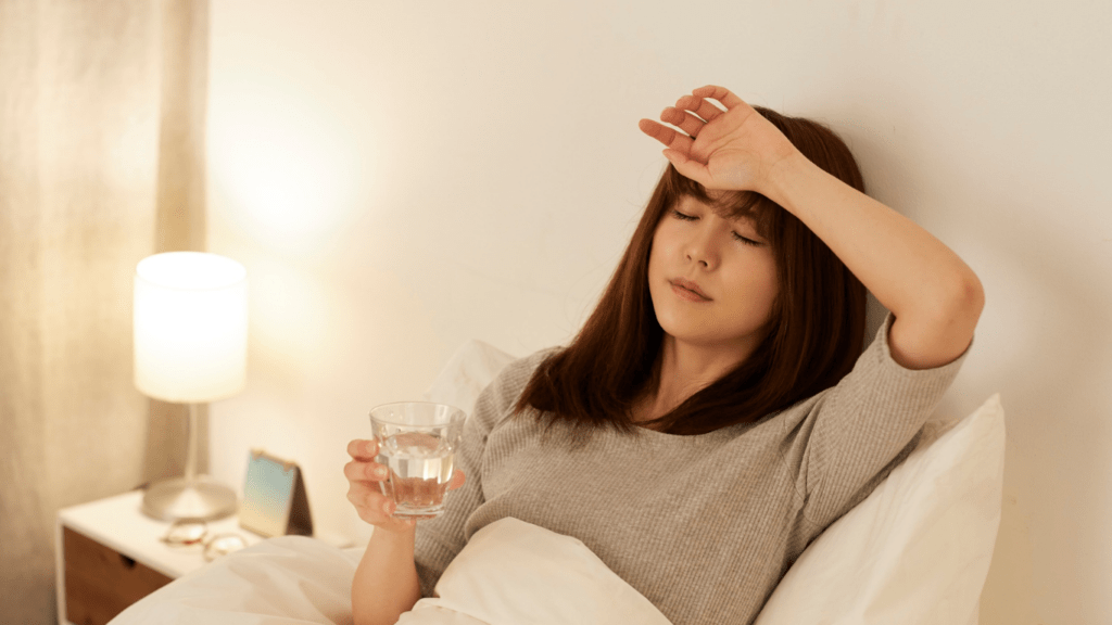 A person laying on the couch with their head in their hands.