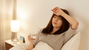 A person laying on the couch with their head in their hands.