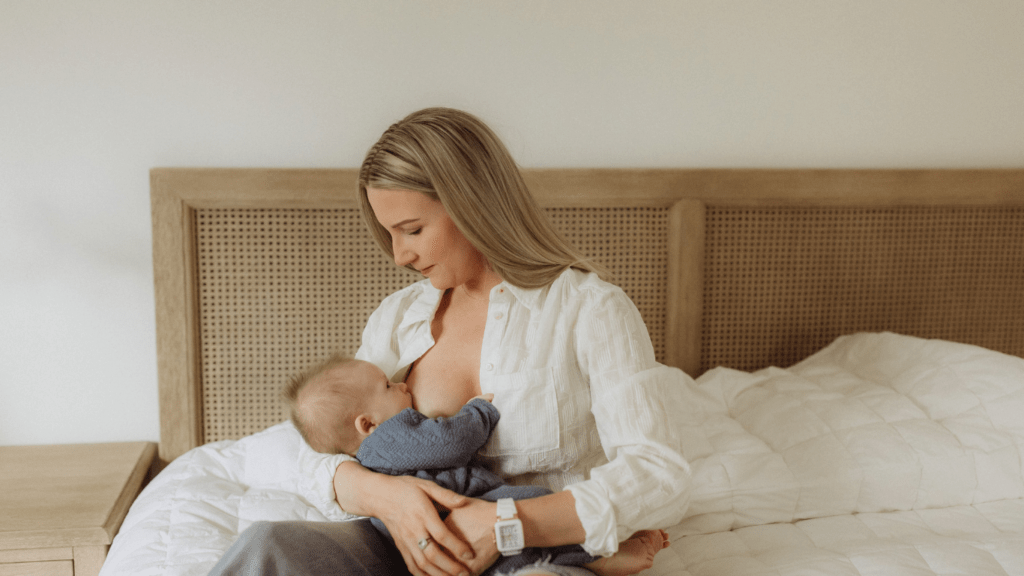 A person breastfeeding a baby while sitting on a couch.