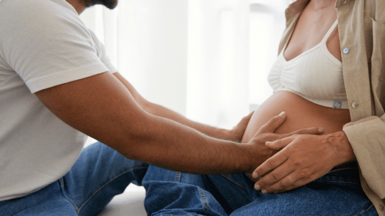 pregnant person and person holding hands