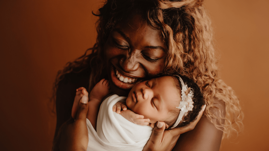 A parent and child pose for a portrait in the studio
