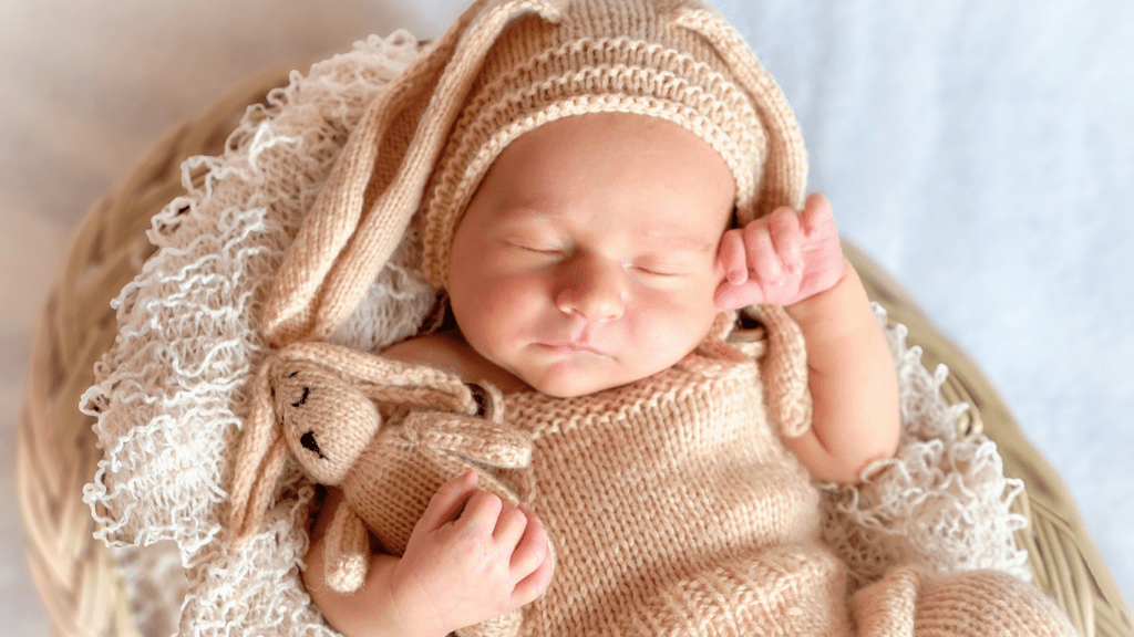 a newborn sleeping with a stuffed animal