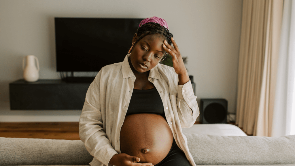 A pregnant person is holding their stomach