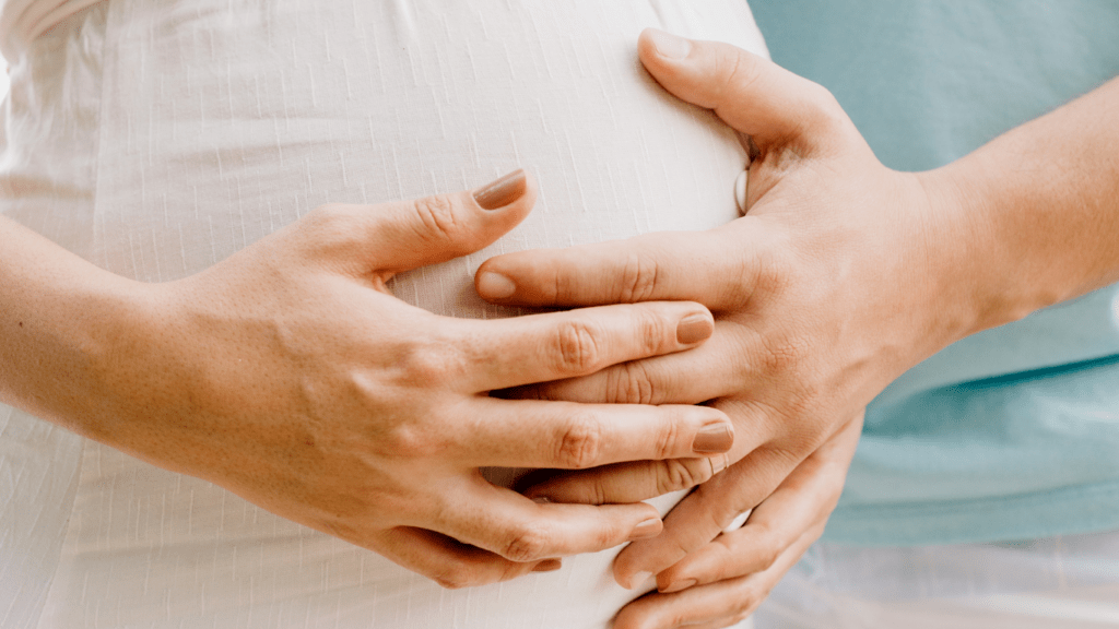pregnant person and person holding hands