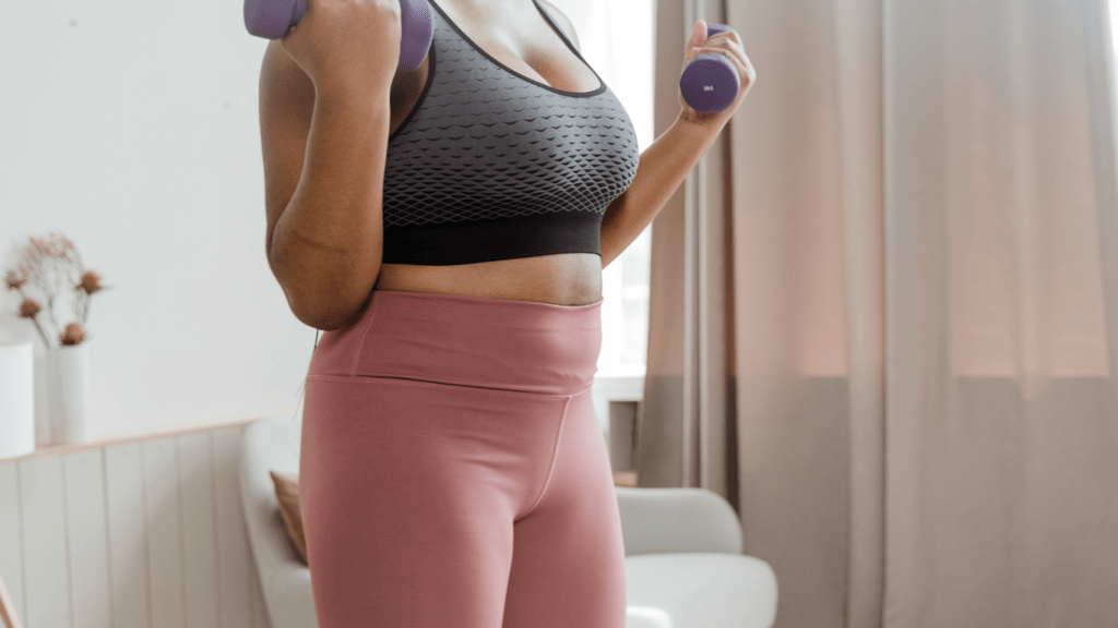 woman exercising with dumbbells at home